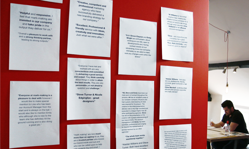 A wall in the mark-making* studio covered in client feedback