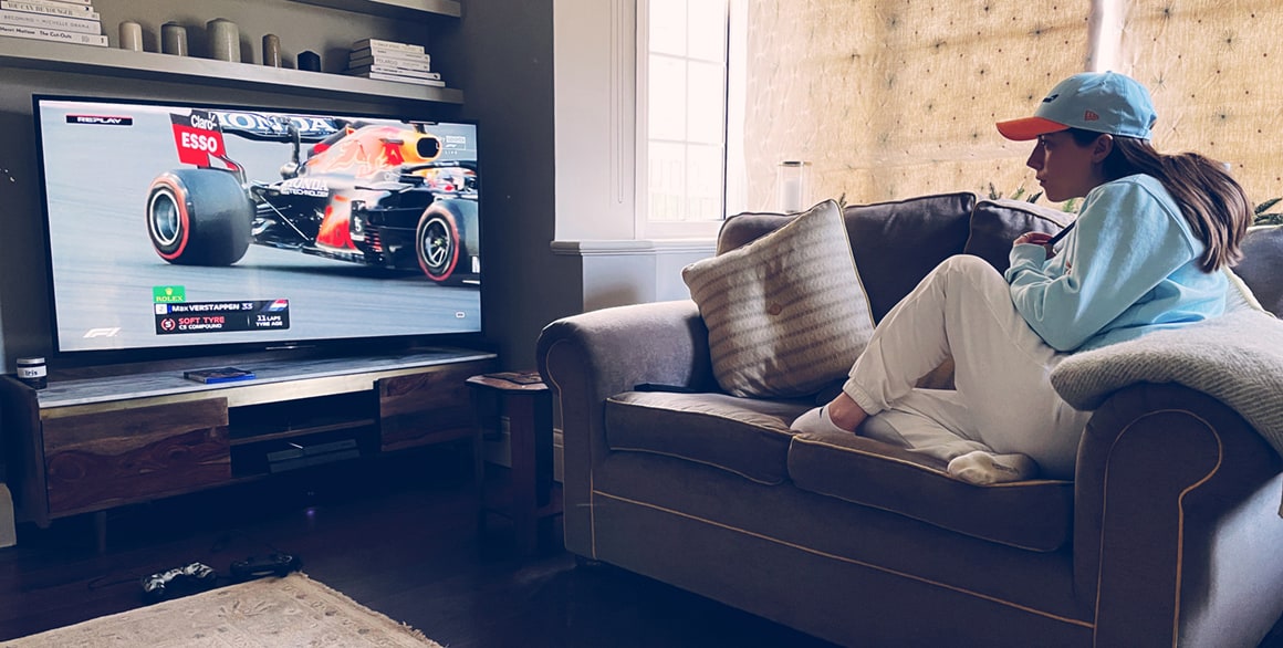 A photograph of Steve’s daughter watching F1 from the sofa of their home.