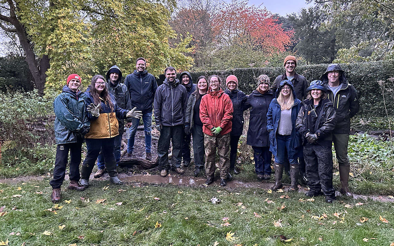 The mark-making* team gathered for group photo at Hidcote Gardens after volunteering, wearing muddy outdoor clothing and colourful hats